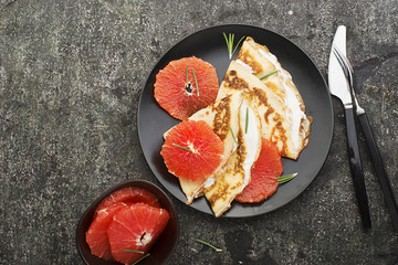 Thin crepes with red orange, rosemary and cream in the filling. Top view. Food Concept.