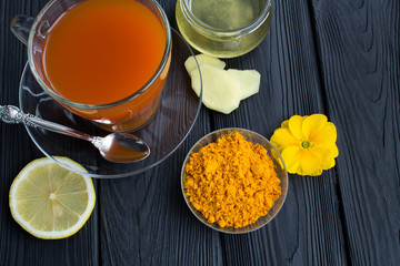 Tea with turmeric on the black  wooden background.View from above.