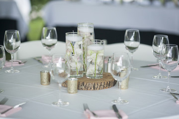 Table decorated for wedding reception with orchids in water.