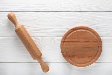 empty wooden cutting board and rolling pin on a light wooden background