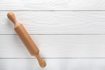 wooden rolling pin on a light wooden background