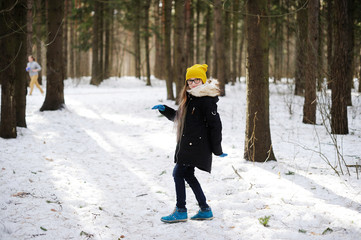 Stylish kid girl in winter forest