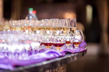 out catering, glasses with white and red wine, champagne, whiskey, juice and mineral water are on  table for the guests of  event
