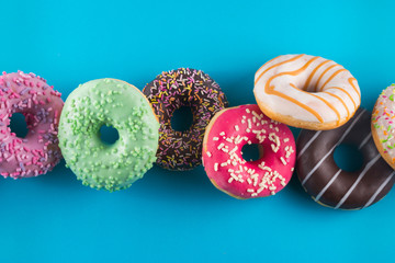 Tasty doughnuts on blue background. Close up