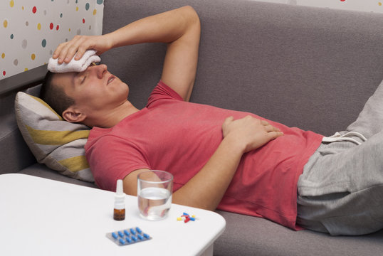man with headache lying on the sofa