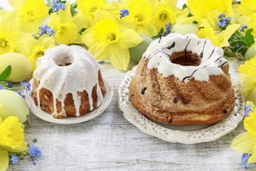 Traditional easter cakes and bouquet of daffodils in the background.