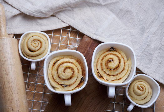 Close-up of cinnamon buns in cups on metal grate at kitchen