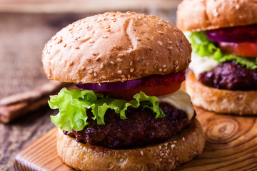 Hamburger with lettuce, cheese. tomato, red onion