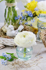 Easter table rustic decorations with white ranunculus flower, hay and wicker wreath.