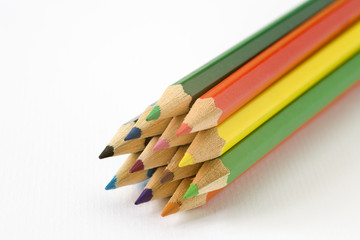 Fototapeta premium Childrens colouring pencils on a plain white textured paper background