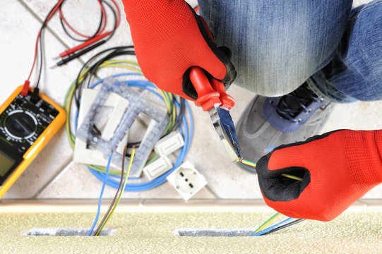 Electrician technician at work with safety equipment on a residential electrical system