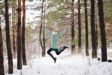 beautiful slender girl jumping up outdoors in winter. Portrait of a cute sporty girl who jumps up...