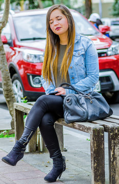 Beautiful Young Woman Well Dressed Falling Sleep On A Public Chair In The Streets Of The City Of Quito, Ecuador