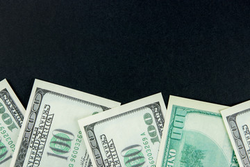 One hundred dollar bills on black background with copyspace