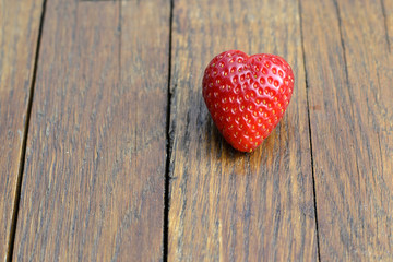 red strawberries lie on a shabby board
