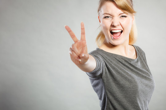 Cheerful lady makes v gesture.