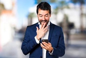 Handsome man talking to mobile on unfocused background