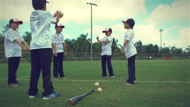 Slow motion of cute kids stretching at baseball practice
