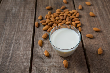 glass of almond milk on wooden surface