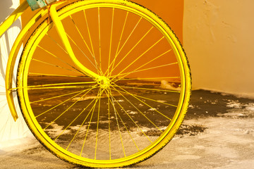 Yellow wheel of a bicycle.