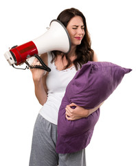 Beautiful young girl with a pillow holding a megaphone