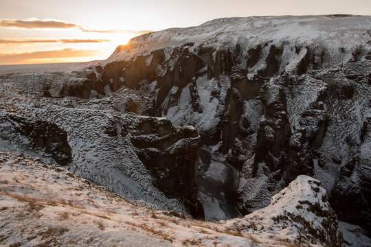 Fjadr&aacute;rglj&uacute;fur canyon pass in winter viewing upstream during the sunset. Icelandic gorge Fjadrargljufur in wintertime. Famous place on the south Iceland near Kirkjub&aelig;jarklau&shy;stur with river Fja&eth;r&aacute;. 