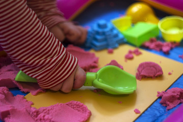 Pink kinetic sand, educational game for children. The development of motor skills in boys and girls