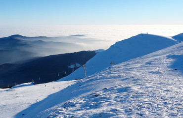 Clouds in the Carpathian Mountains and ski slopes at the Sinaia resort.
