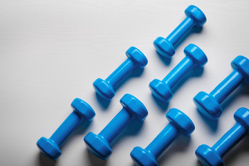 many blue dumbbells on a white background ,concept preparing to fitness sports equipment top view mock up