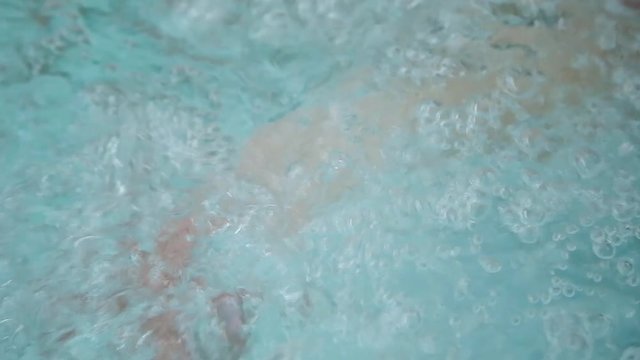girl enjoys the water bubbles in the Jacuzzi