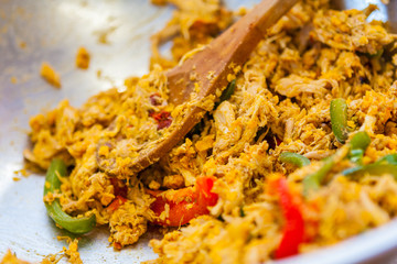 Frying Pan with Shredded Chicken, Peppers and a Wooden Spoon