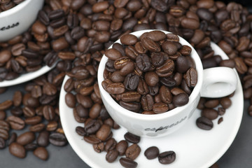 Still life of roast coffee beans and espresso cups