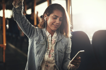 Young woman riding on a bus listening to music