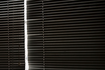 Blinds on a window of dark gray color.