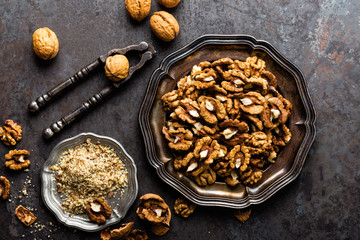 Walnut kernels and whole walnuts on rustic old wooden table