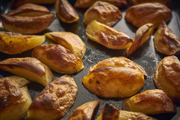 Golden baked potato wedges on a baking tray