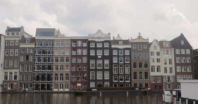 Archetypal apartments along a canal in Amsterdam. Cinematic 4K UHD footage / establishing shot.
