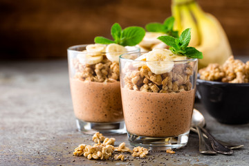 Layered chocolate chia pudding parfait with banana, granola and yogurt, dessert