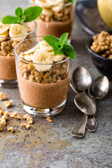 Layered chocolate chia pudding parfait with banana, granola and yogurt, dessert