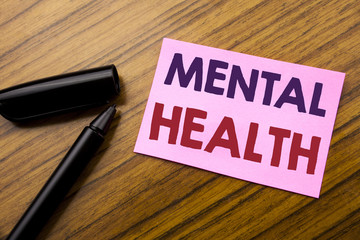 Word, writing Mental Health. Business concept for Anxiety Illness Disorder Written on sticky note red paper, wooden background with pen. Note stick on the desk.