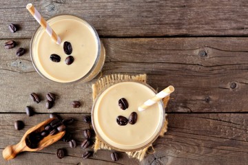 Coffee, banana smoothie in two glasses. Top view, corner orientation over a rustic wood background,