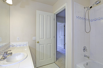 Interior of white bathroom with mosaic backspalsh tiles.