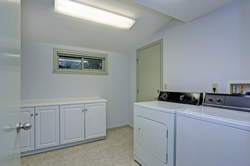 Laundry room with vaulted ceiling