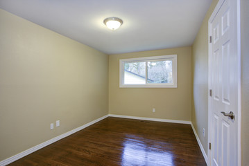 Empty room, taupe walls, hardwood floor in a luxury home.