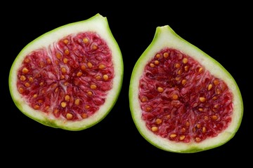 Fig fruit halved isolated in black background.Red inside with seeds.