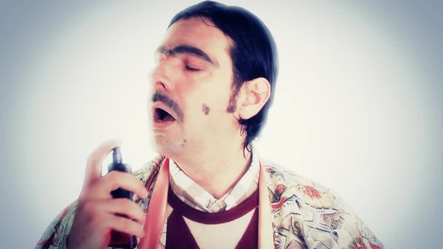 An ugly nerd in a comfy dressing gown, spraying perfume over his face, and inside his mouth by mistake, coughing and spitting. Funny comedy scene, close-up shot.

