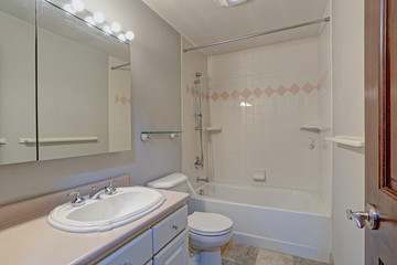 White bathroom design with vanity cabinet and tub