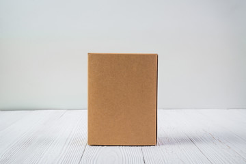 Empty Package brown cardboard box or tray on bright wooden table with copy space.