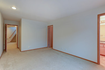 Empty apartment interior features white walls and beige carpet floor