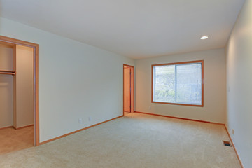 Empty apartment interior features white walls and beige carpet floor
